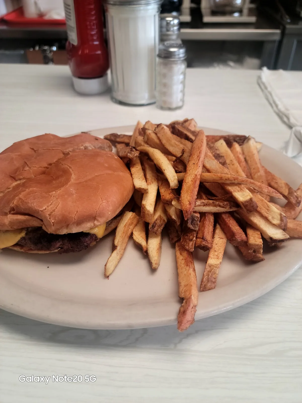 A cheeseburger with a plate of hand cut fries at City Cafe in South Houston